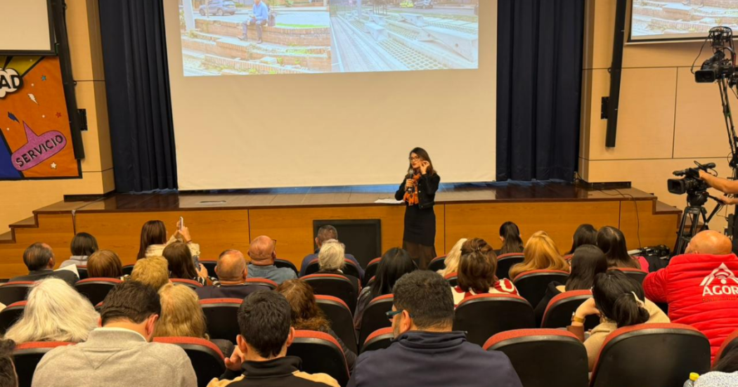 Foto de una mujer hablando en un auditorio 