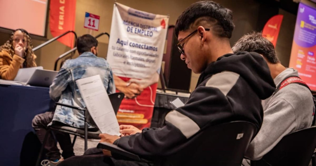 Joven con su hoja de vida en una feria de empleo en Bogotá