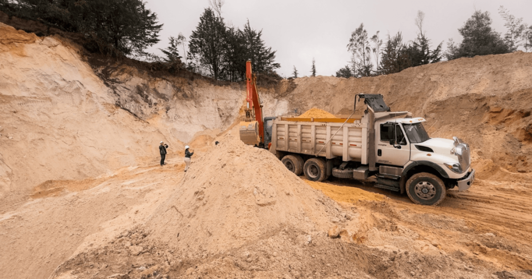 Camión de carga y retroexcavadora junto a montículos de arena en una zona de extracción intervenida durante operativo contra la minería ilegal en Chocontá.