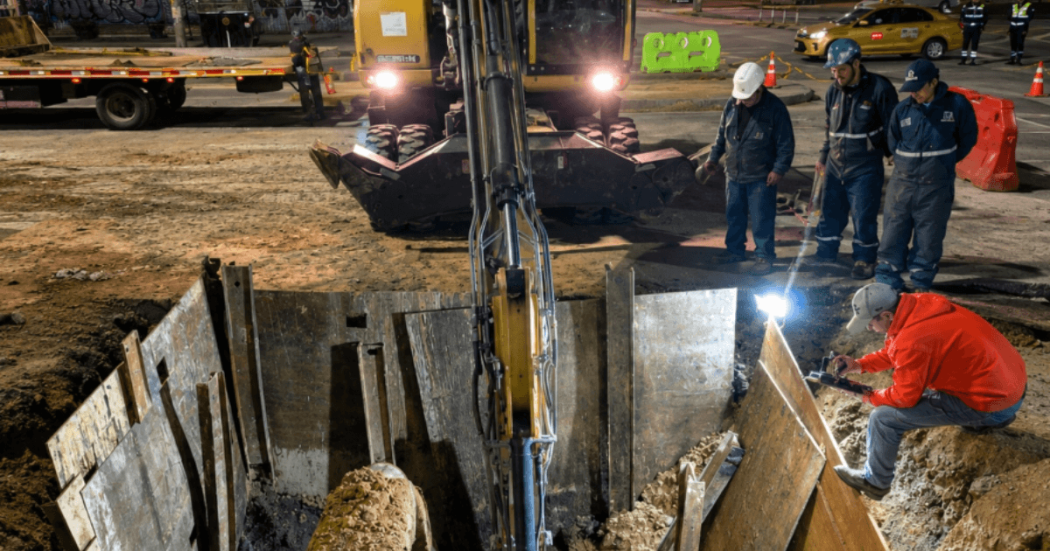 Foto que muestra un hueco en el piso y personas trabajando 