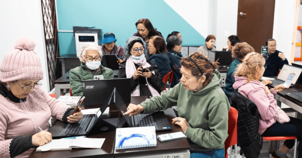 Mujeres mayores usando celulares y computadores. 