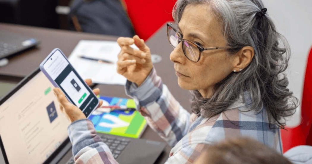 Mujer sentada frente a un computador portátil. 
