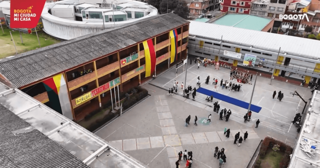 Foto que muestra un colegio y estudiantes hablando 