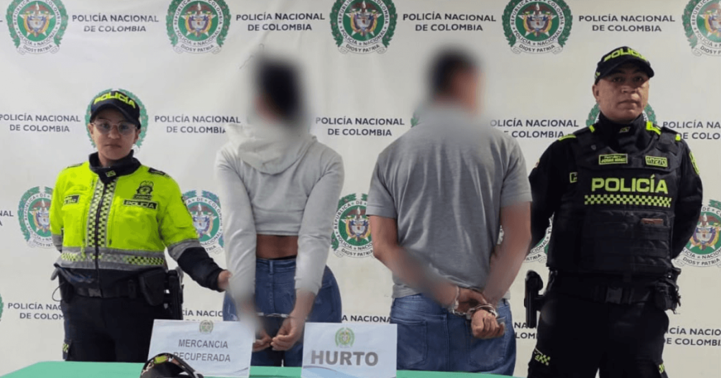 Un hombre y una mujer, capturados, en medio de dos policías.