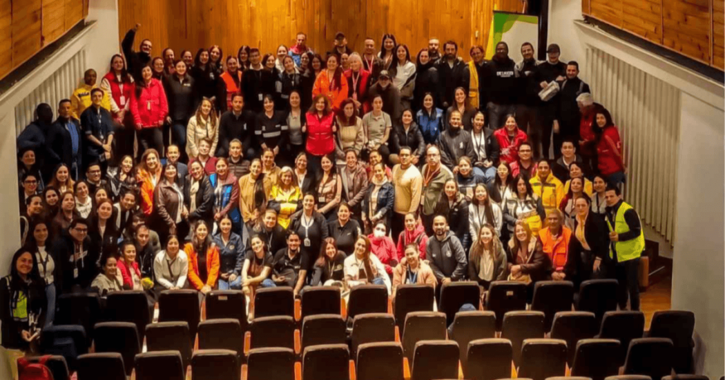 participantes de los Comités de Ayuda Mutua reunidos en un auditorio, posando para una fotografía grupal en las escaleras y pasillos laterales.