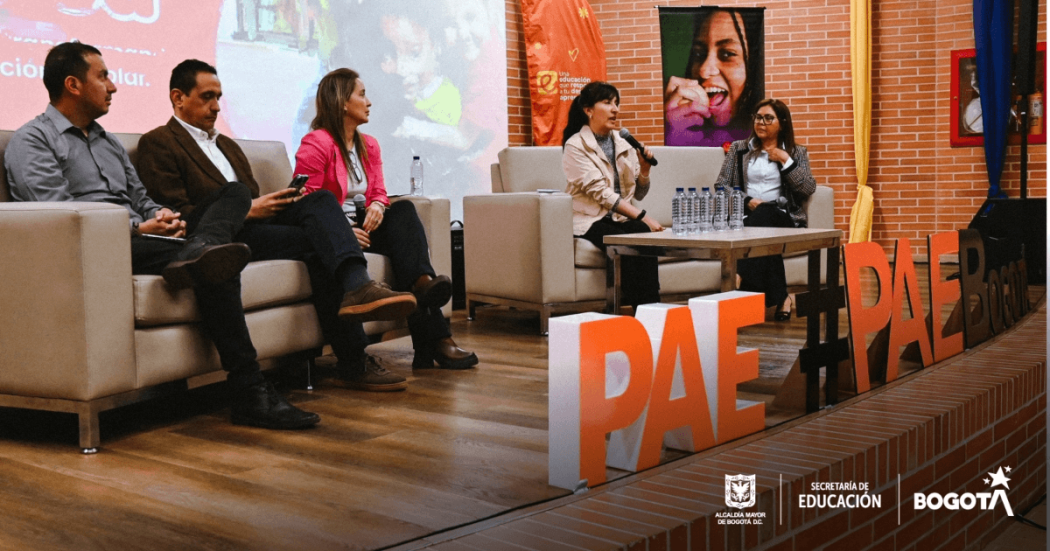 Foto que muestra personas hablando en una conferencia