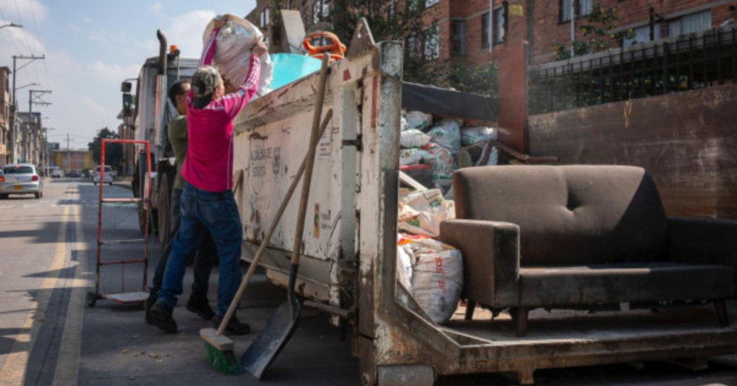 Foto que muestra personas dejando residuos en una volqueta