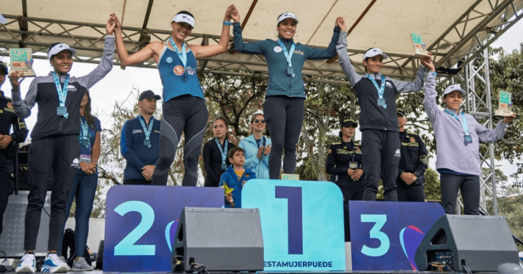 Deportistas con medallas ocupan los tres primeros lugares de un podio durante una ceremonia de premiación de la Carrera de la Mujer 2026.