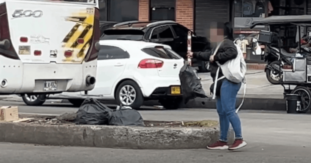 Mujer arrojando bolsas de basura en la calle. 