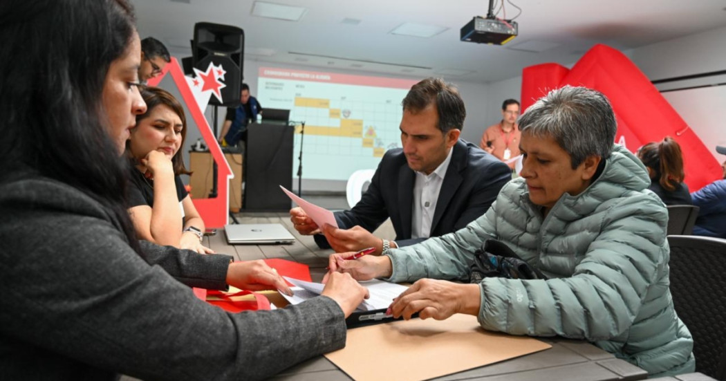 Foto que muestra personas firmando documentos 