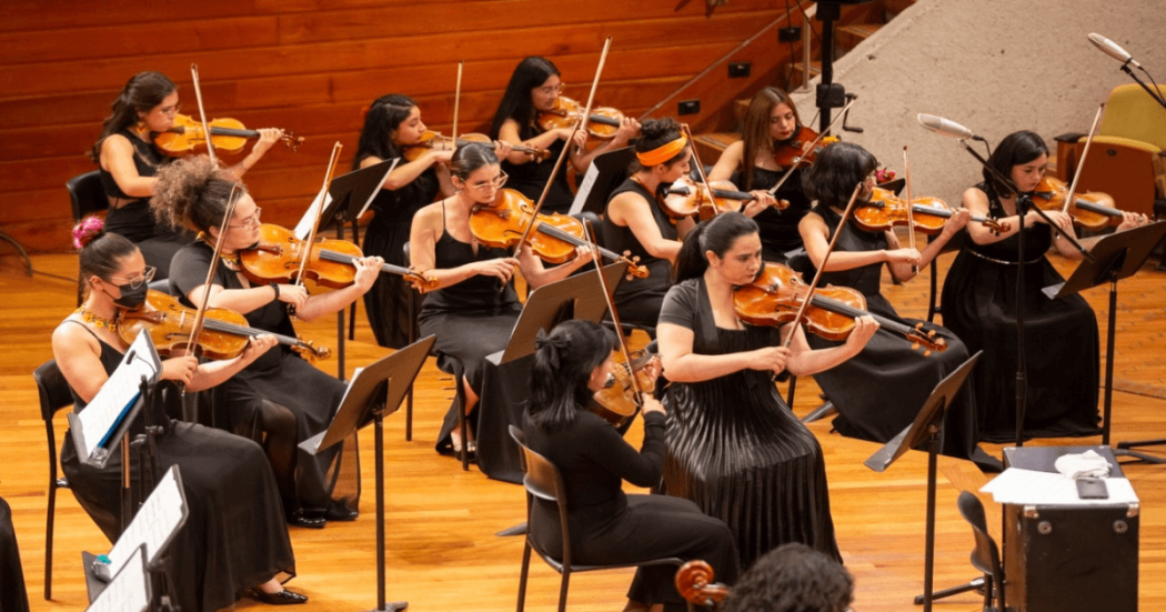 Imagen de mujeres tocando violín pertenecientes a la Orquesta Filarmónica de Mujeres