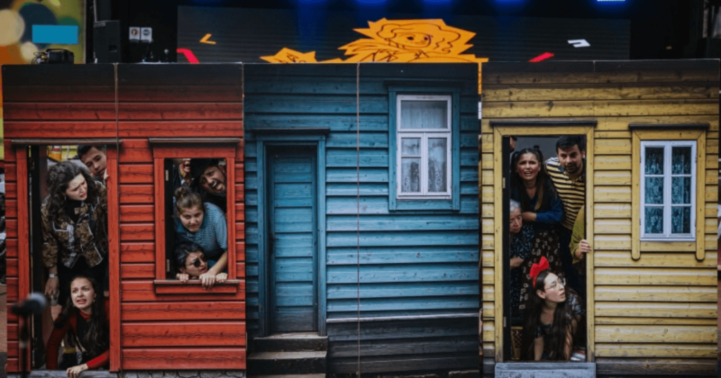 Imagen de simulacion de casas de colores con personas saliendo de dos de ellas