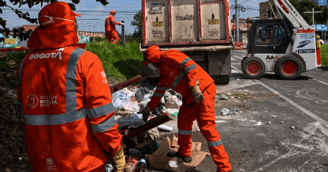 Foto que muestra dos personas con el uniforme de Aguas Bogotá levantando residuos 