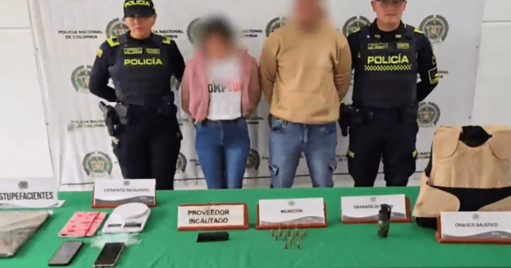 Dos personas capturadas en medio de dos policías. 