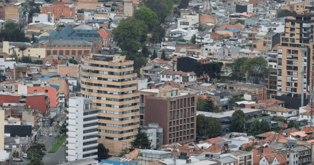 Vista panorámica de un sector urbano de Bogotá con edificaciones residenciales y comerciales de diferentes alturas. En primer plano se observan varios edificios de apartamentos y oficinas.