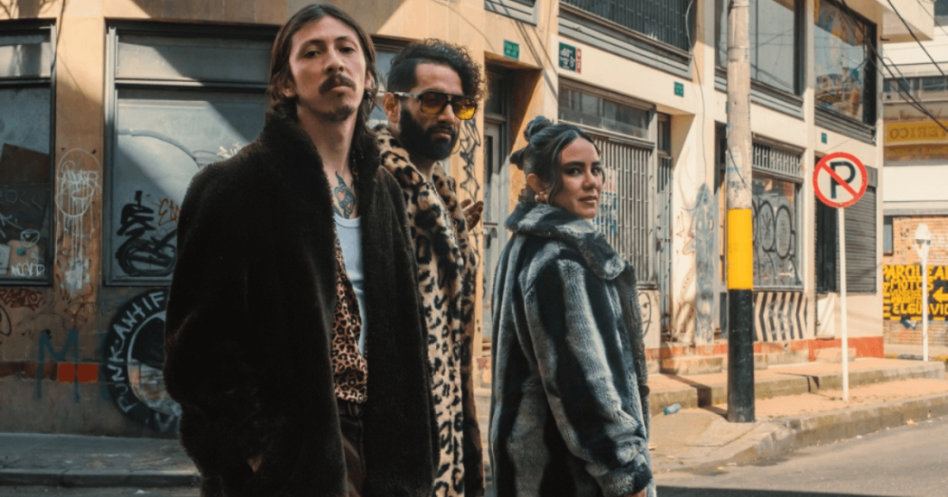 Imagen de 2 hombres y una mujer con abrigos con fondo de calle con graffitis 