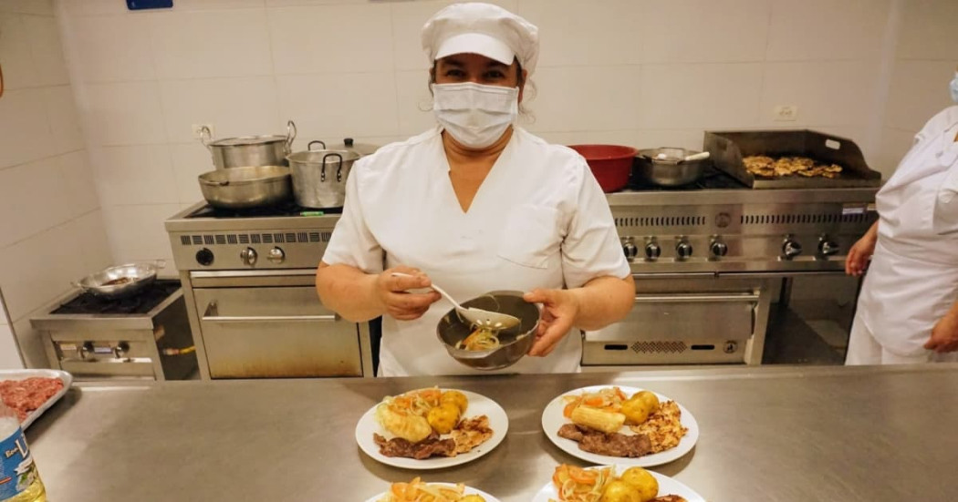 Una señora preparando alimentos en un comedor comunitario