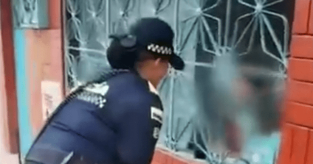 Mujer policía verificando la situación en la que se encontraban estos dos niños.