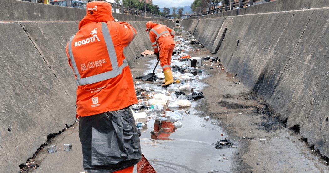 Foto que muestra personas limpiando un canal de agua 