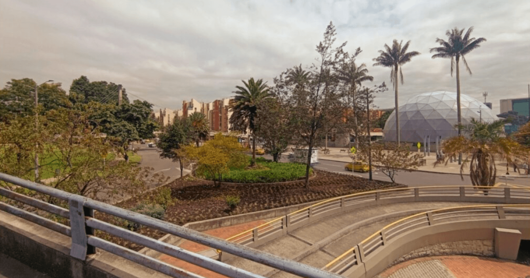 Jardinera renovada con caminos peatonales, vegetación nativa, árboles y zonas verdes en los alrededores de Salitre Plaza y Maloka, junto a una vía urbana en Bogotá.