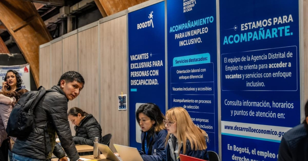Participante en la Megaferia de Empleo junto a funcionarias de la Alcaldía de Bogotá