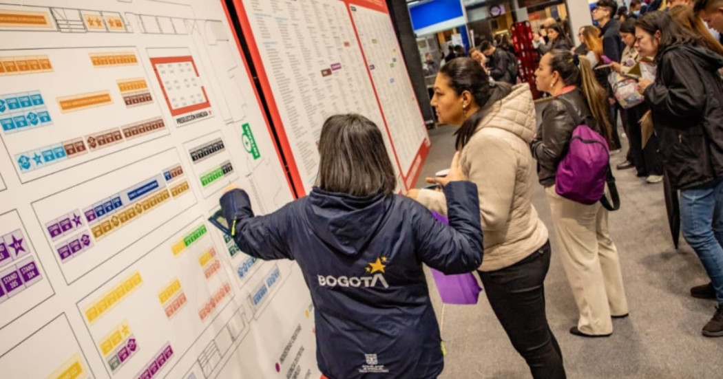 Funcionaria de la Alcaldía de Bogotá guiando a participante de la Meferia de Empleo