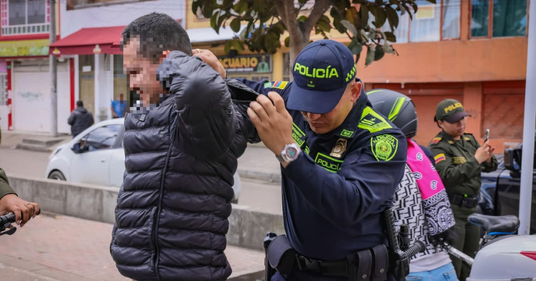 Foto de un uniformado de la Policía de Bogotá requisando a una persona durante la intervención en el parque Bellavista de Kennedy en Bogotá.