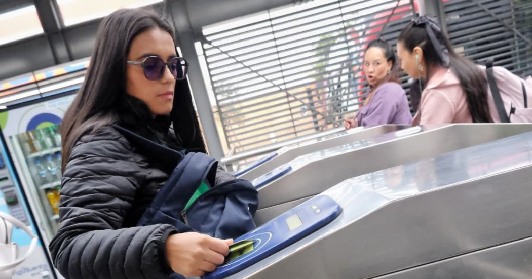 Foto de una mujer accediendo a una estación de TransMilenio en Bogotá.