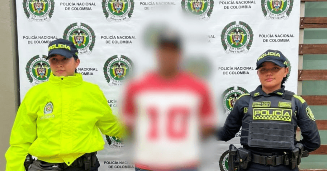 Foto de un hombre capturado en medio de dos policías.