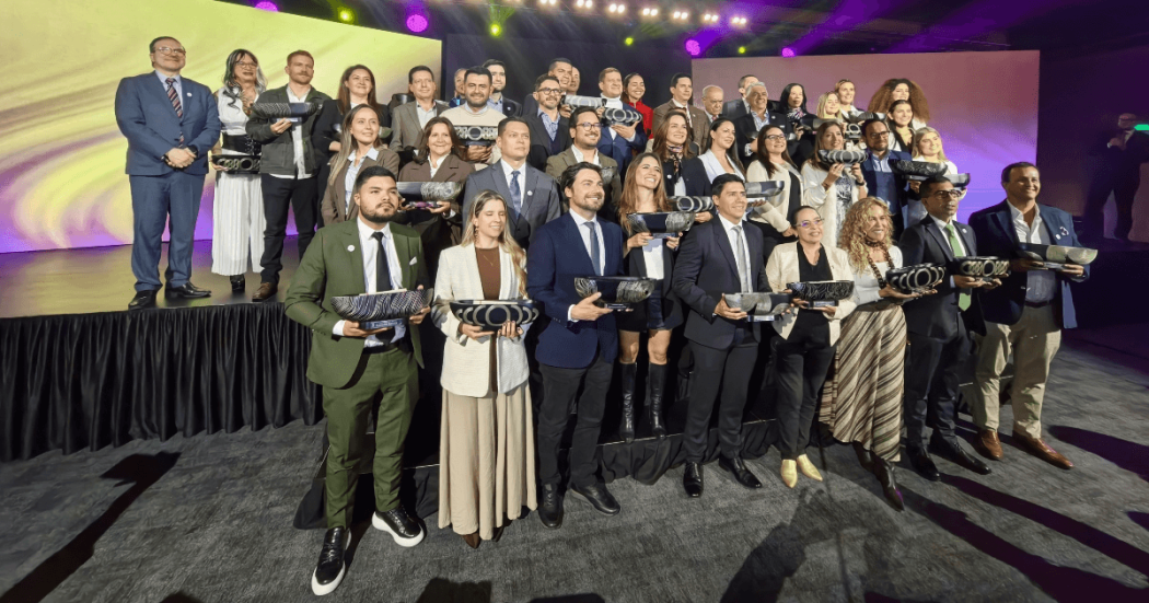 Foto que muestra personas sonriendo con un trofeo en las manos