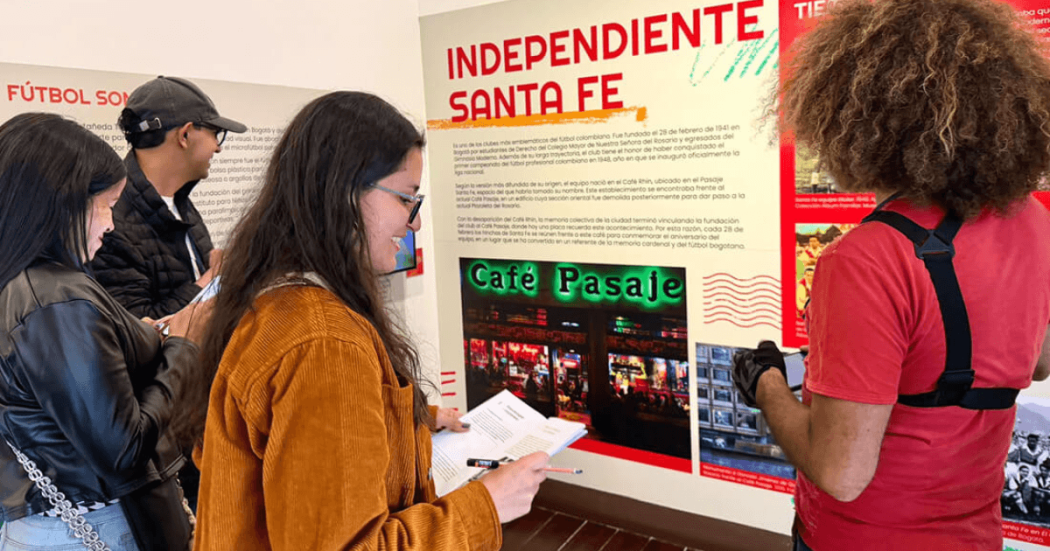 Imagen de personas al frente de cartelera historia Café pasaje en el centro de Bogotá