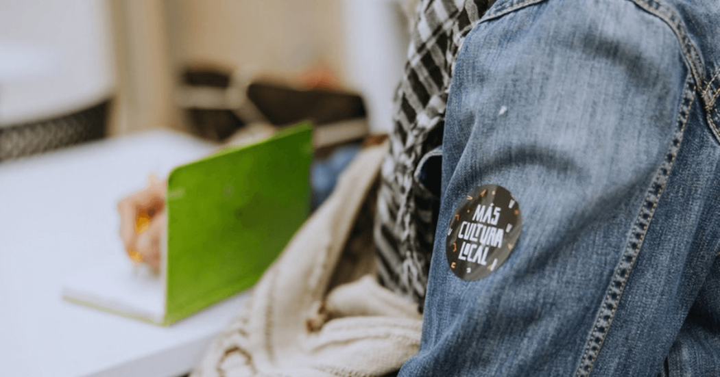 Imagen del logo Más Cultura local sobre chaqueta de jean