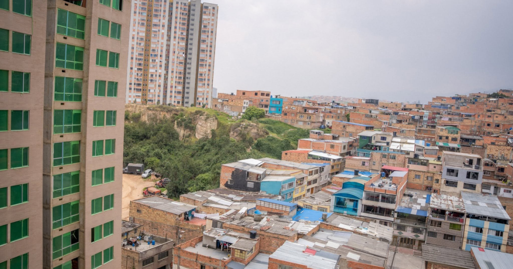 Vista panorámica de un barrio de Bogotá con viviendas de ladrillo, edificios residenciales y zonas verdes.
