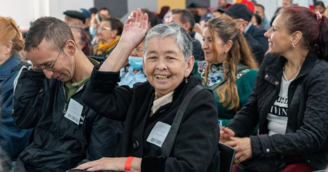 Foto de una señora levantando la mano 