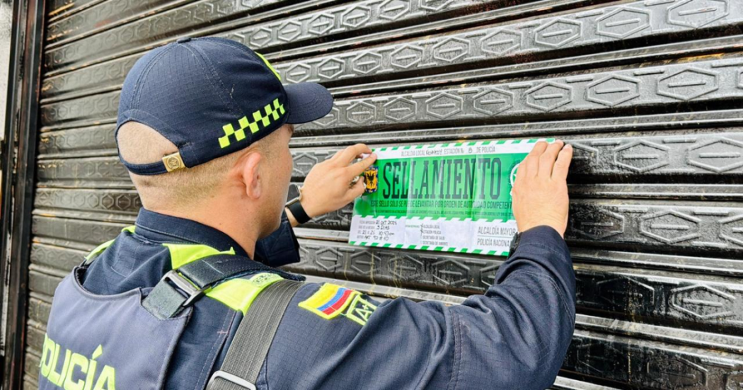 Foto de un policía sellando un establecimiento 