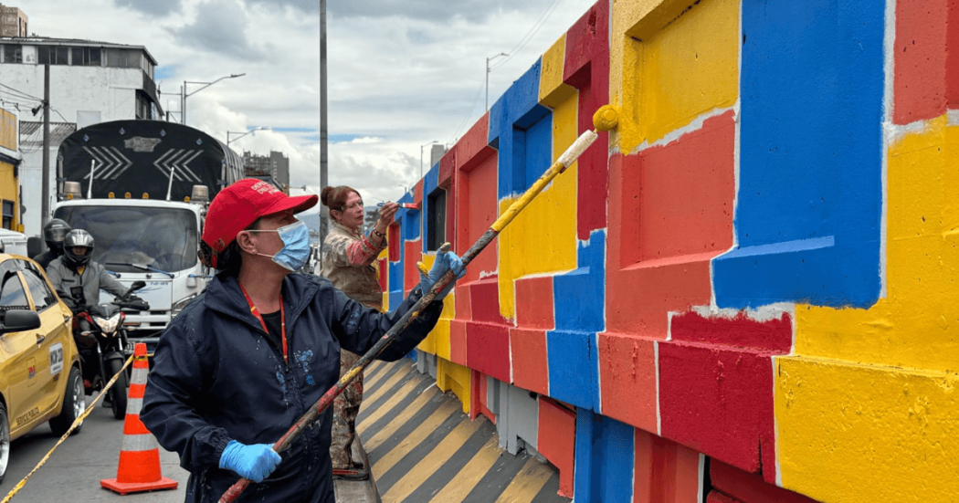 Defensoras del espacio público pintando un bajo puente en Bogotá.