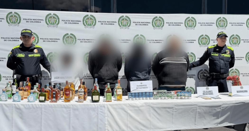 Cuatro de los seis capturados, junto a los elementos incautados, en medio de dos policías.