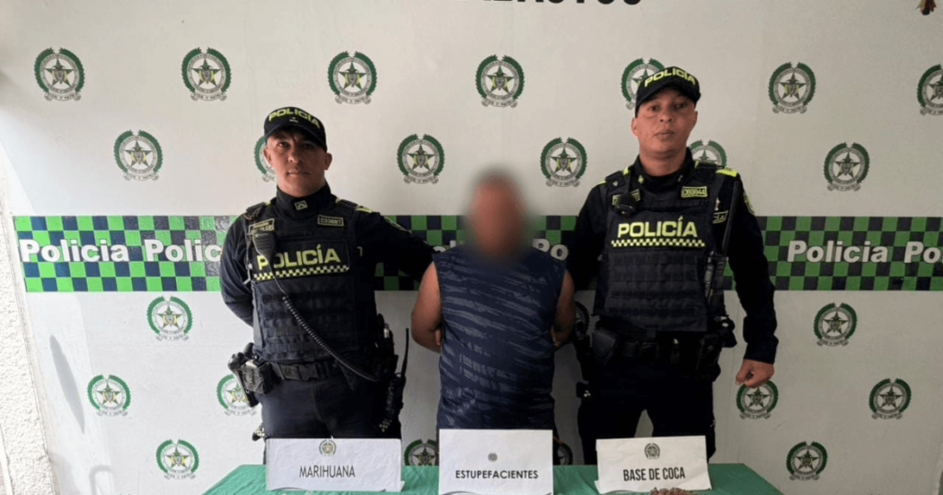 Foto de hombre capturado en medio de dos policías.