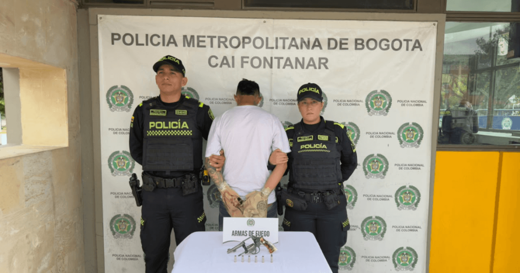 Foto de hombre capturado en medio de dos policías.