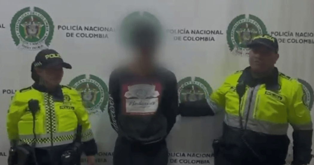 Foto de hombre capturado en medio de dos policías.