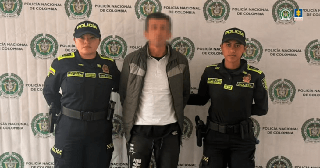 Foto de hombre capturado en medio de dos policías.
