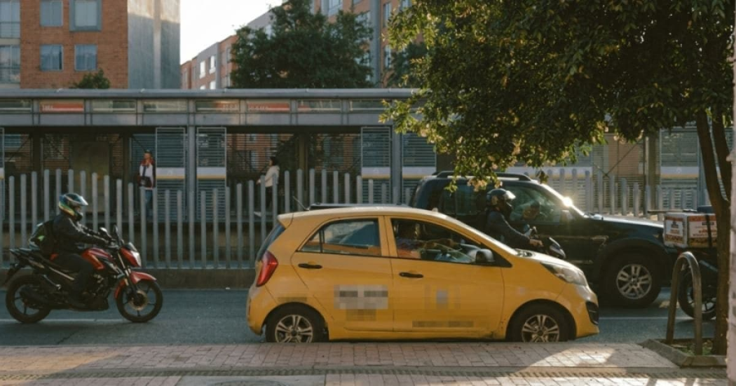 Foto donde se encuentra un taxi y otros vehículos en una vía de Bogotá