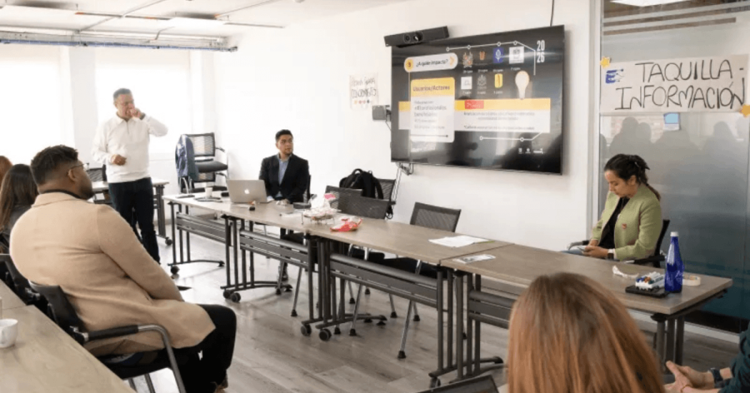 Foto que muestra personas hablando en un salón 