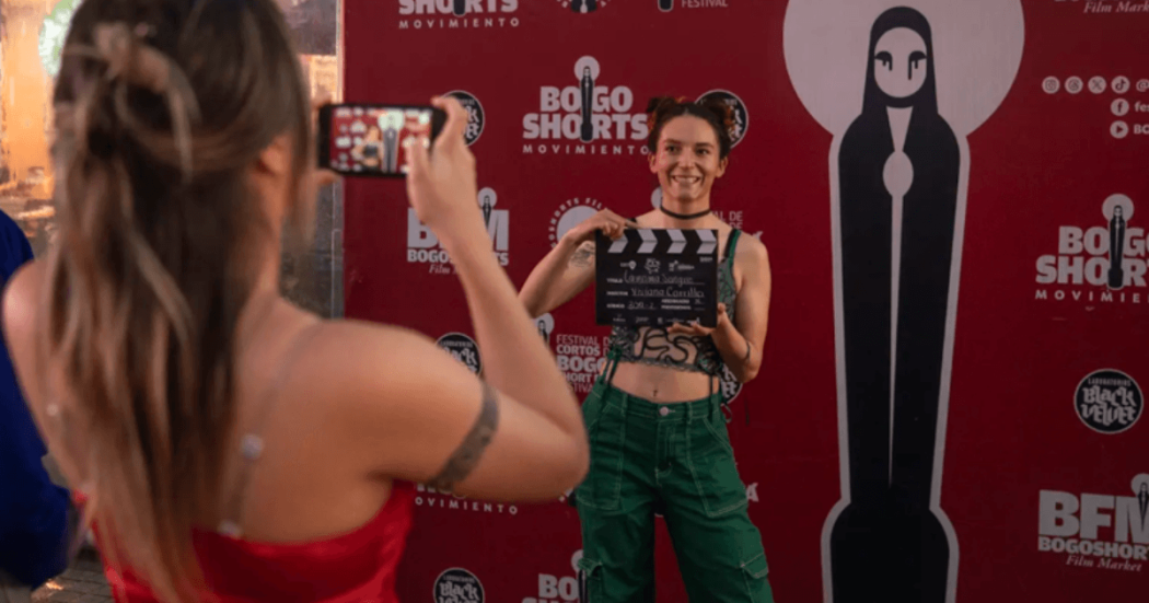 Imagen de una mujer fondo de Bogoshorts con una claqueta y otra grabándola con un celular