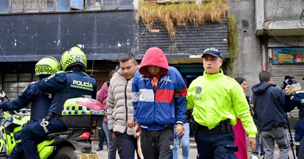 Foto de dos capturados esposados.