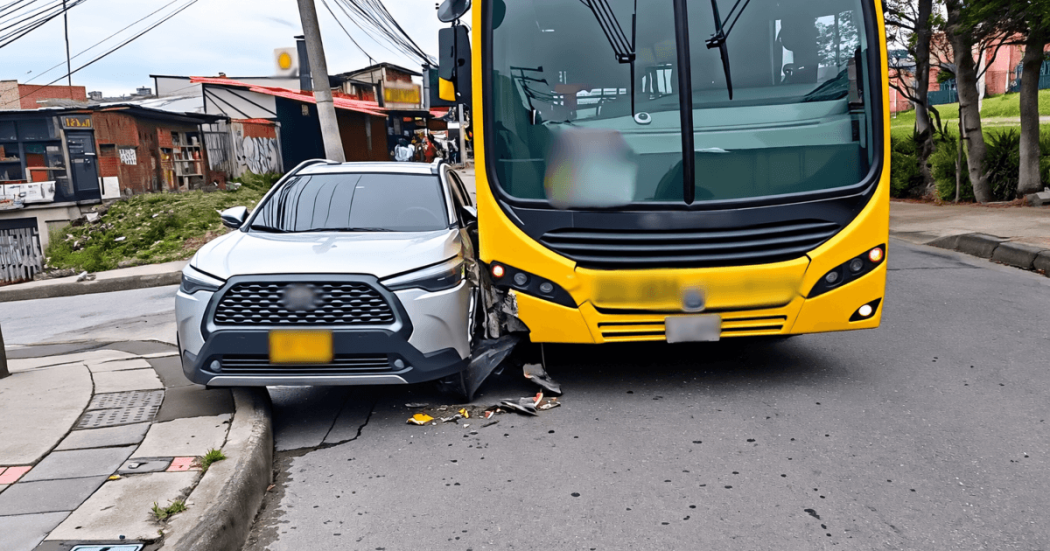Primer plano de una colisión entre un bus articulado amarillo de TransMilenio y un vehículo particular gris en una vía de Bogotá