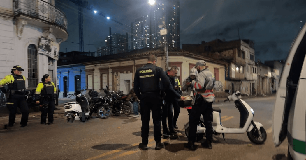 Foto de Gestores del Orden y policías verificando una moto eléctrica robada.
