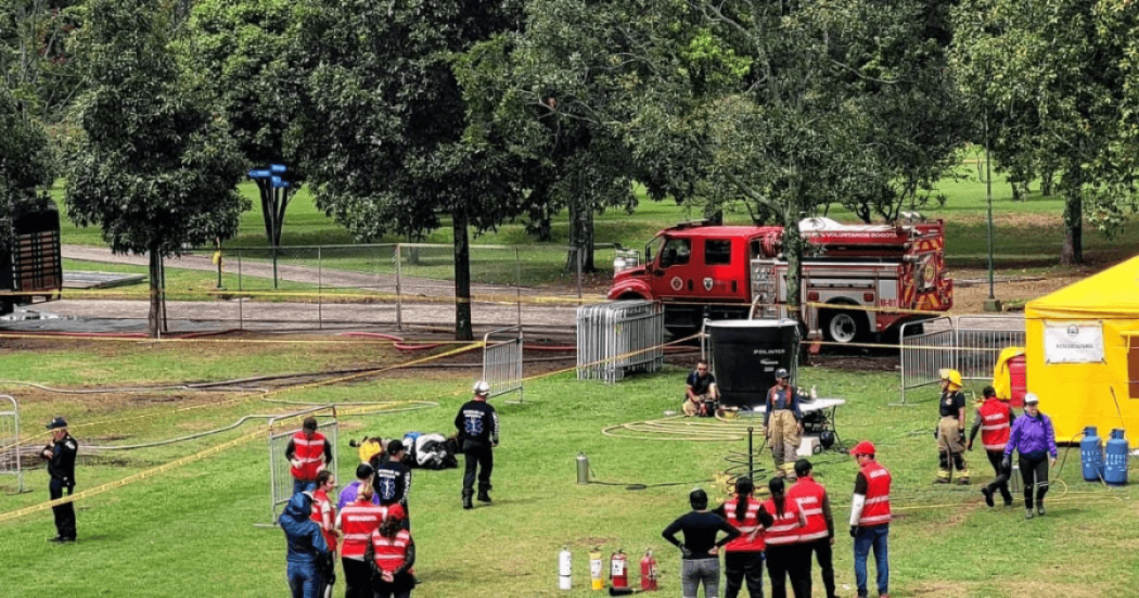 Personal de atención de emergencias y gestión del riesgo participa en un ejercicio de coordinación en una zona verde con conos de señalización, mientras un vehículo de emergencia permanece ubicado al fondo del parque Simón Bolívar en Bogotá.