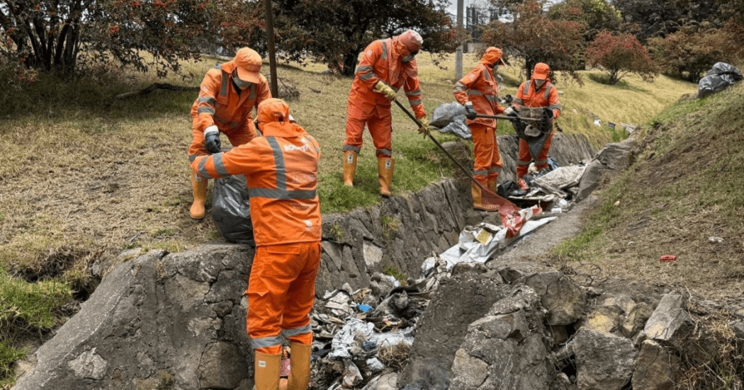 Foto que muestra personas con el uniforme de Aguas Bogotá limpiando las calles