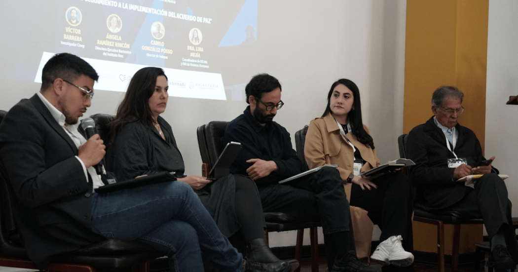 Foto que muestra personas sentadas en una tarima 